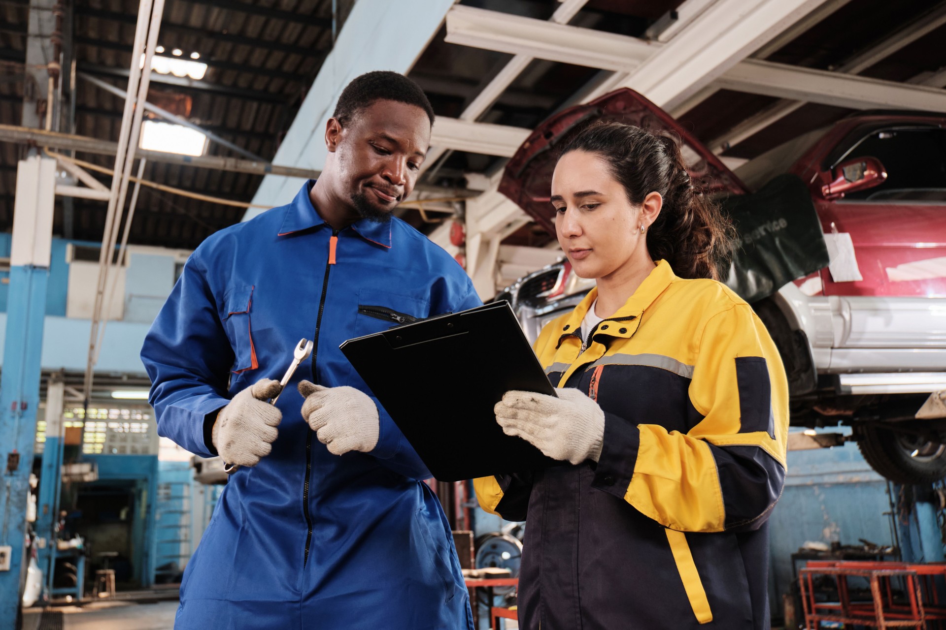 Mechanical coworkers discussing service works at the car garage.