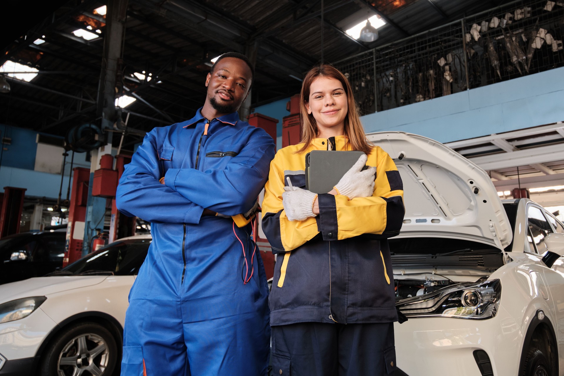 Happy mechanic teamwork, cheerful, arms crossed with smile in fix car garage.