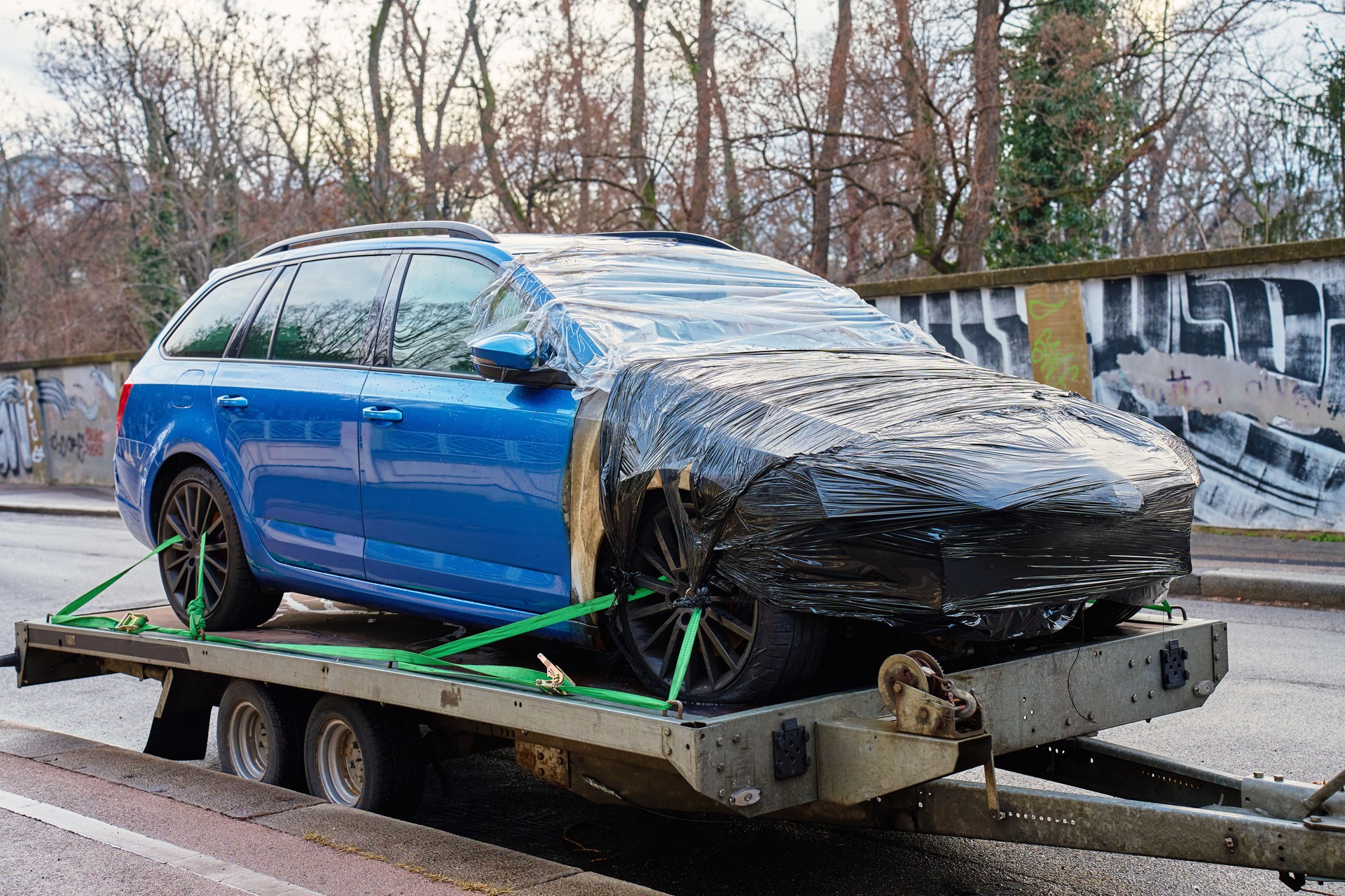 Damaged blue car on tow truck. Crashed vehicle