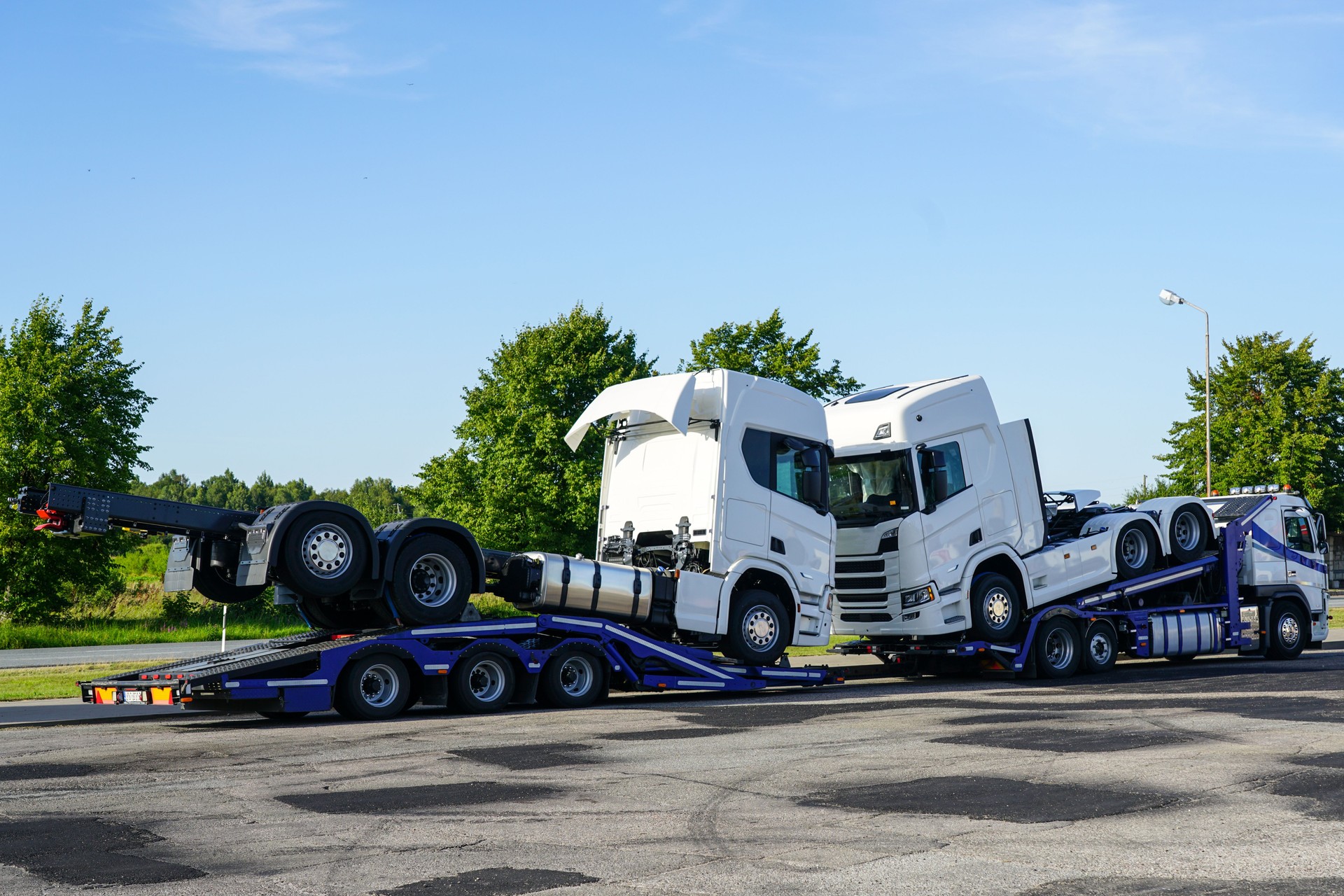 Transporting brand new trucks on specialized truck trailers, delivery to dealers