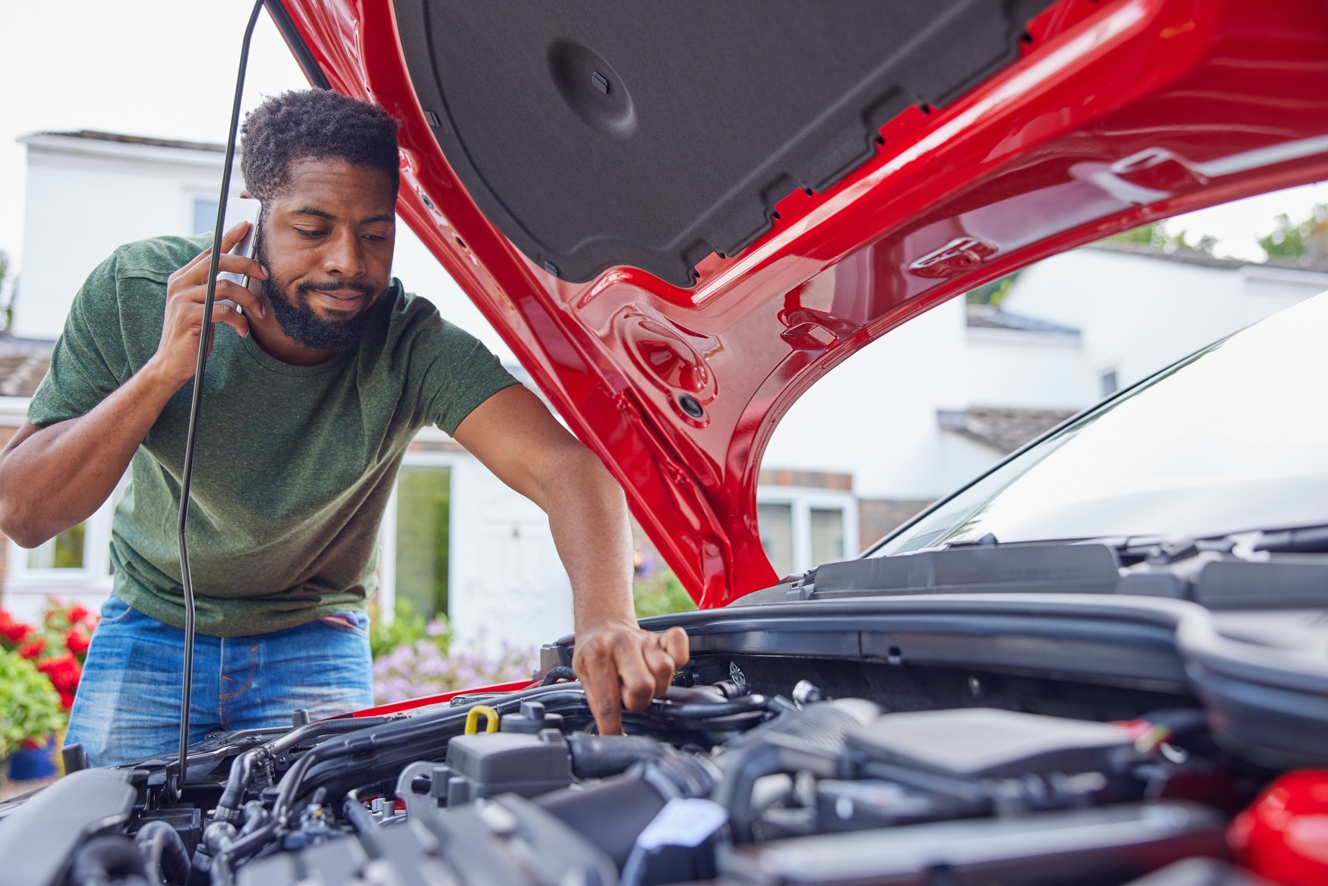 Man Looking At Engine After Car Breakdown Calling Auto Recovery On Mobile Phone